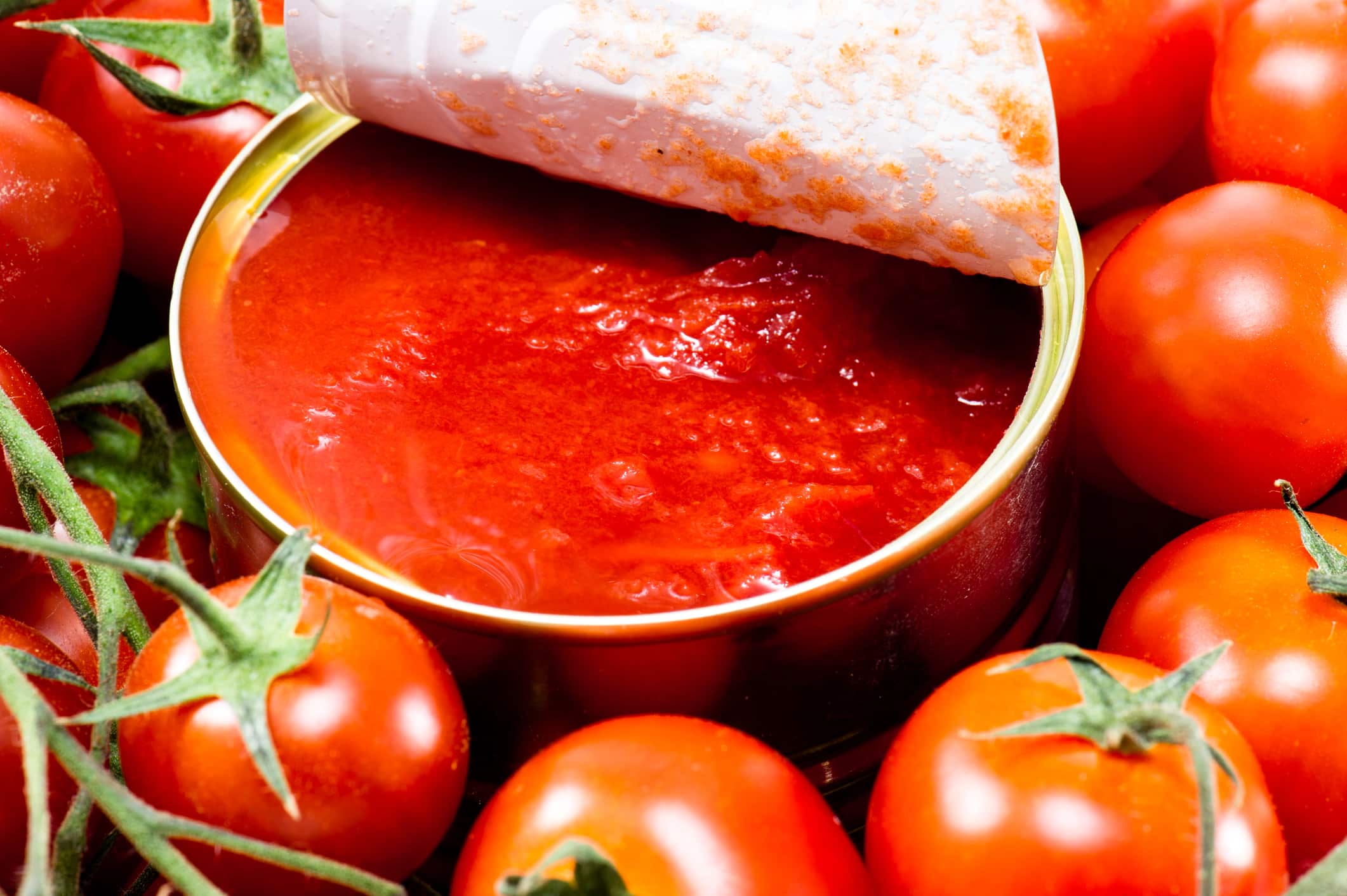 Immagine di un barattolo di passata di pomodoro con un'etichetta evidenziata che indica ingredienti dannosi.